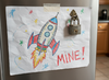 Firefly_Gemini Flash_Child's drawing of a spaceship. The drawing is attached to the front of a...png